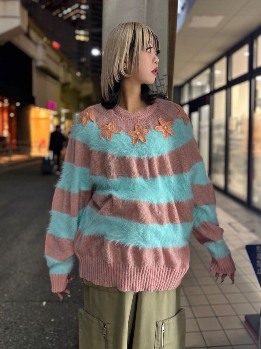 ピンク系のニット/セーター、ベージュ系のパンツ、ブラック系のスニーカーを着用したレディースの冬コーディネートの5枚目の写真