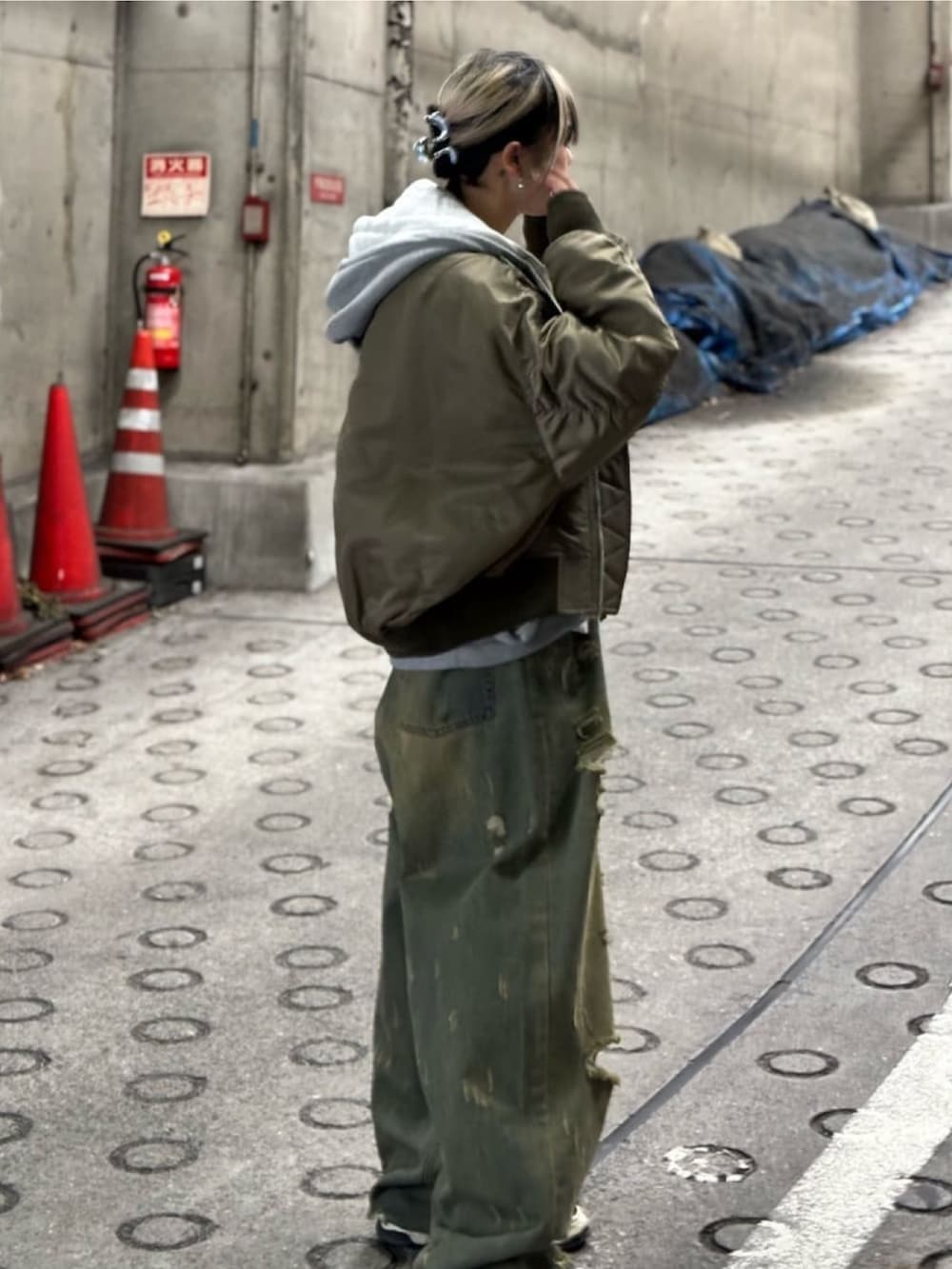 グリーン系のジャケット/アウター、レッド系のTシャツ/カットソー、ブルー系のデニムパンツを着用したレディースの秋コーディネートの4枚目の写真