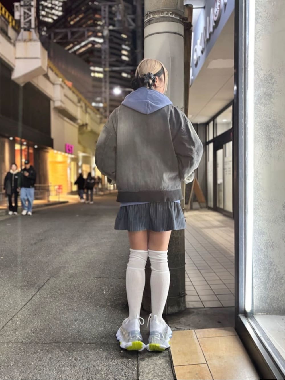 ブルー系のパーカー、ブラック系のジャケット/アウター、ホワイト系のシューズを着用したレディースの冬コーディネートの3枚目の写真