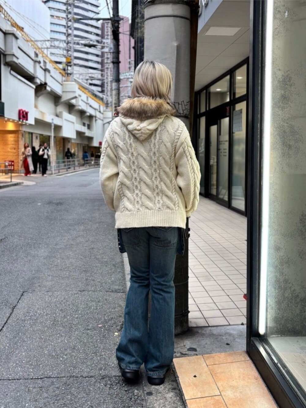 ブルー系のデニムパンツ、ホワイト系のトップスを着用したレディースの冬コーディネートの3枚目の写真