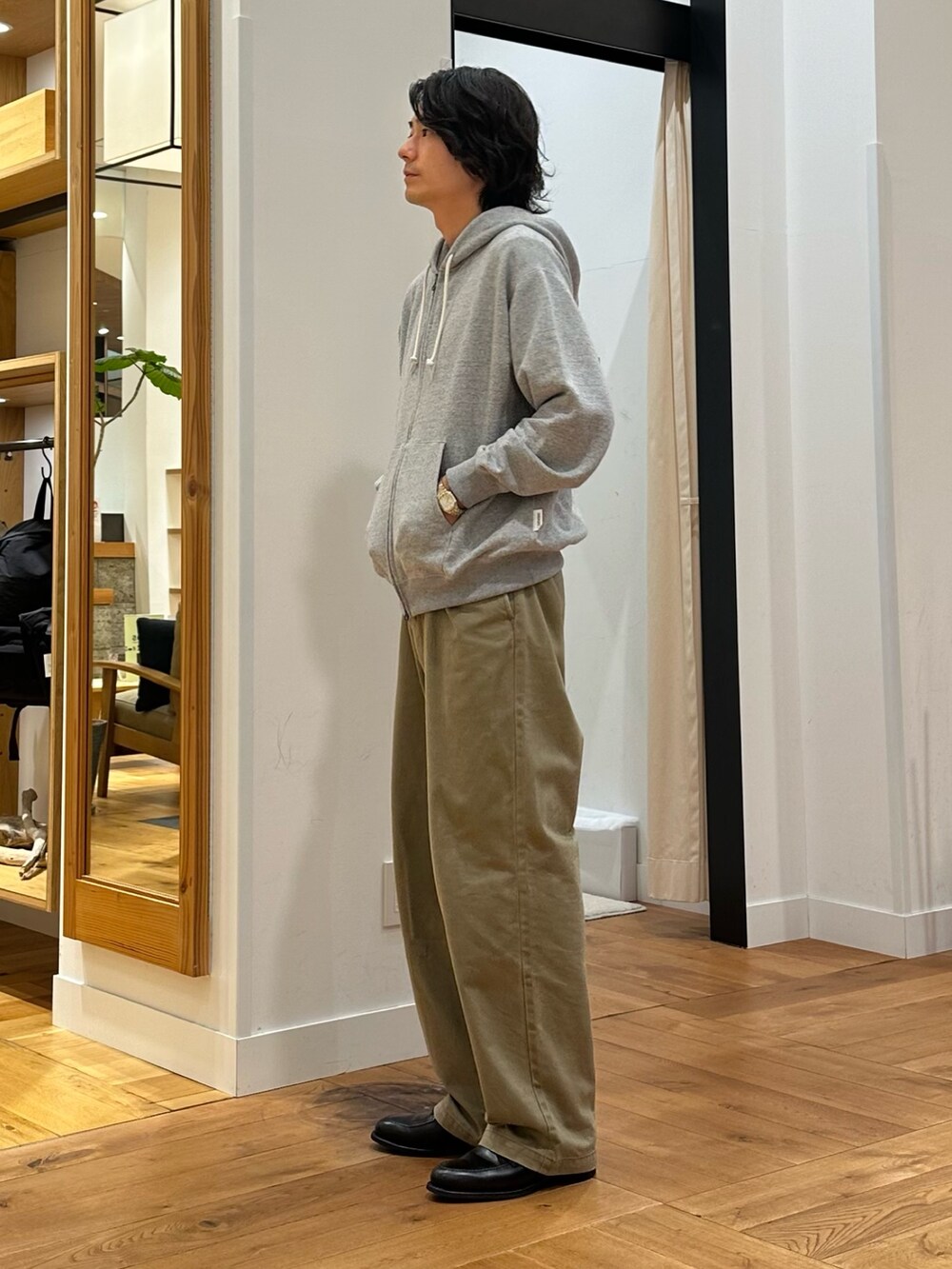 グレー系のパーカー、ホワイト系のTシャツ/カットソー、ベージュ系のその他パンツを着用したメンズの秋コーディネートの3枚目の写真