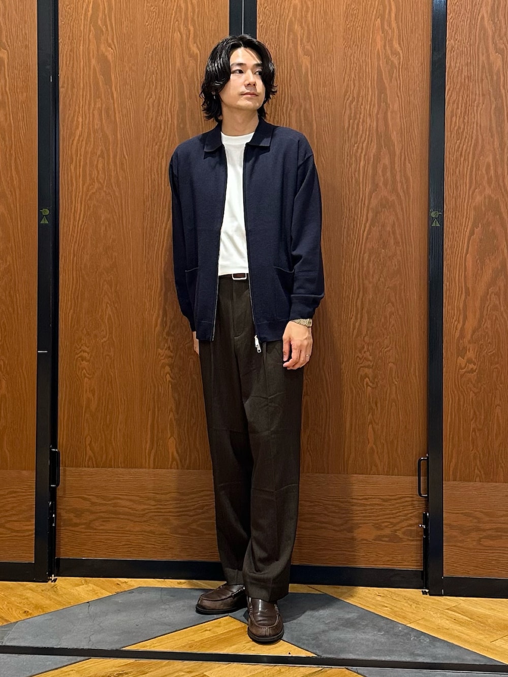ブルー系のニット/セーター、ホワイト系のTシャツ/カットソー、ブラウン系のその他パンツを着用したメンズの秋コーディネートの3枚目の写真