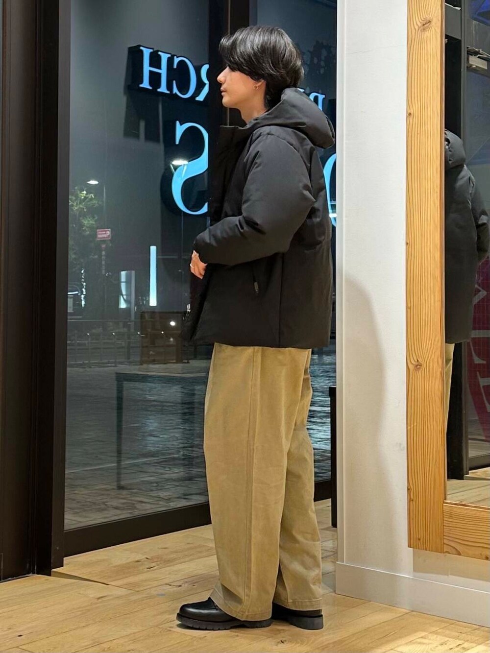 ブラック系のダウンジャケット/コート、ブラウン系のニット/セーター、ブラック系のドレスシューズを着用したメンズの冬コーディネートの2枚目の写真