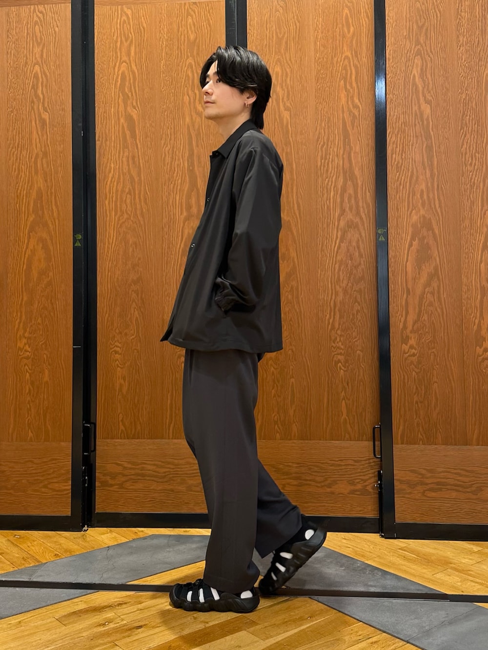 ブラック系のカーディガン/ボレロ、グレー系のその他パンツ、ブラック系のサンダルを着用したメンズの春コーディネートの4枚目の写真