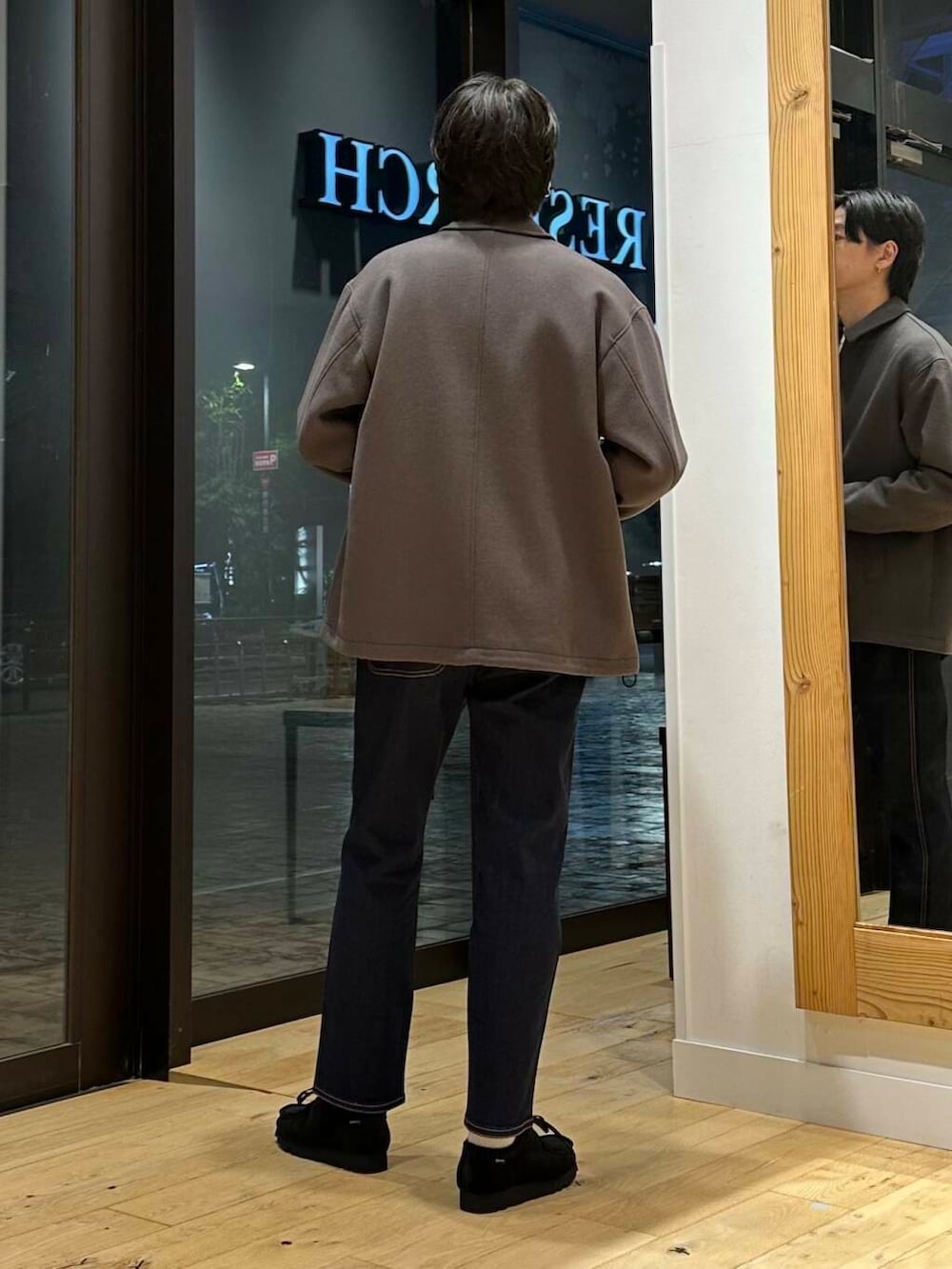 ブルー系のデニムパンツ、ブラック系のブーツ、ホワイト系のニット/セーターを着用したメンズの冬コーディネートの3枚目の写真