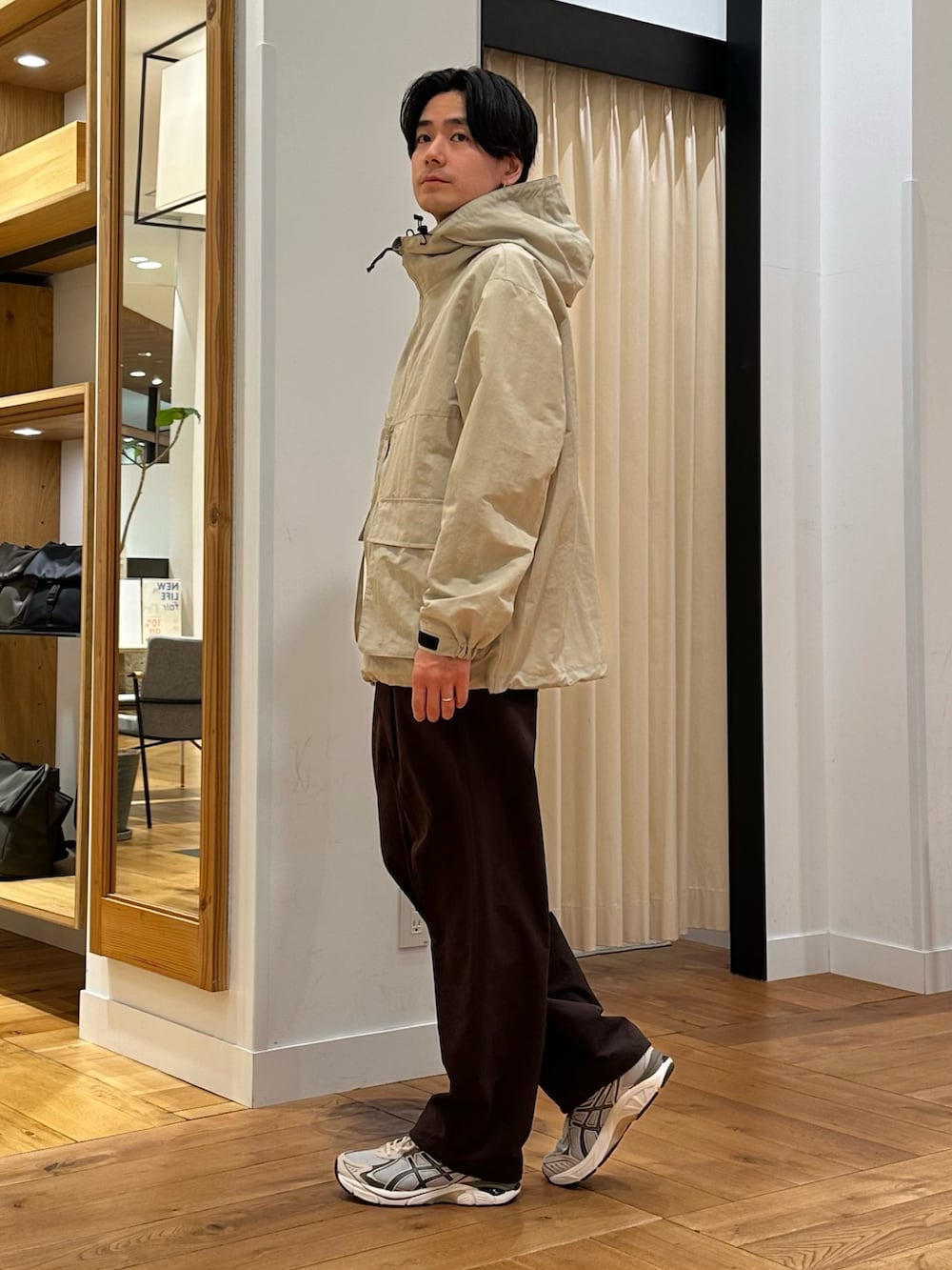 ベージュ系のマウンテンパーカー、ブラウン系のその他パンツ、グレー系のスニーカーを着用したメンズの春コーディネートの2枚目の写真