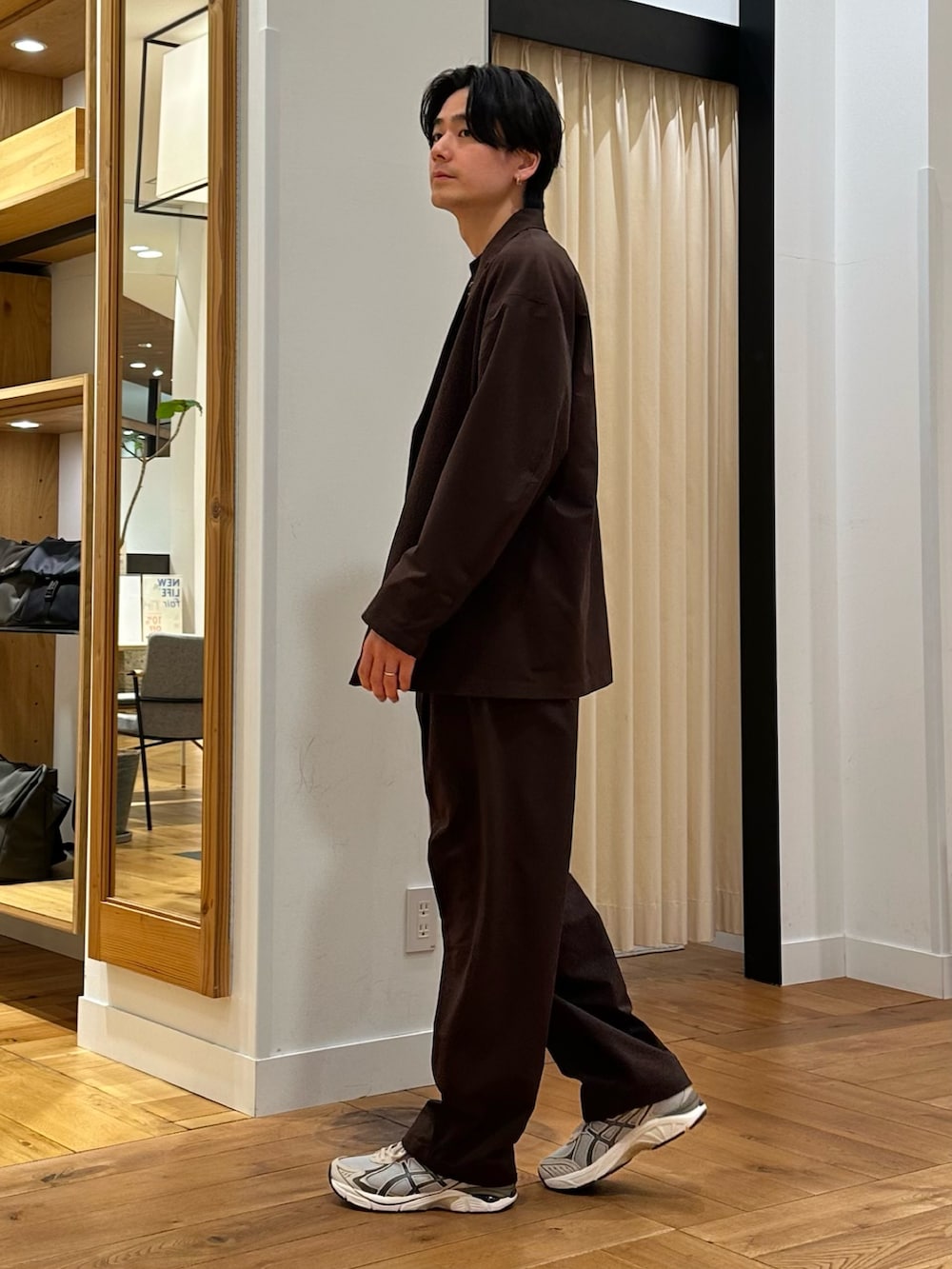 ブラウン系のその他アウター、ブラウン系のその他パンツ、ブラック系のTシャツ/カットソーを着用したメンズの春コーディネートの2枚目の写真