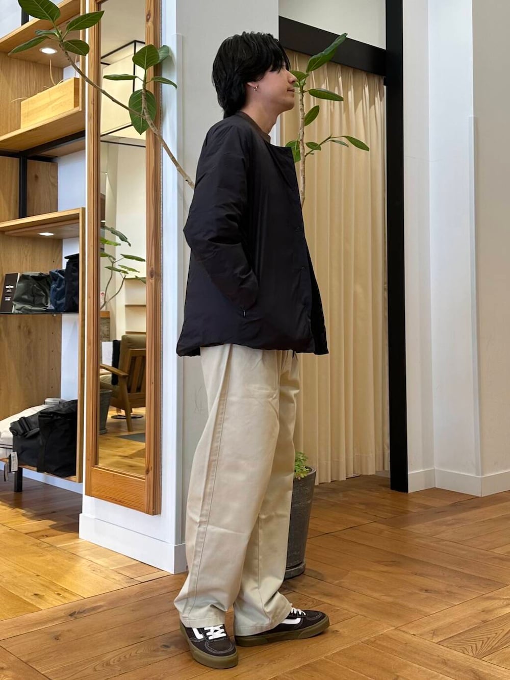 ホワイト系のチノパンツ、ブラック系のダウンジャケット/コート、ブラウン系のニット/セーターを着用したメンズの冬コーディネートの2枚目の写真