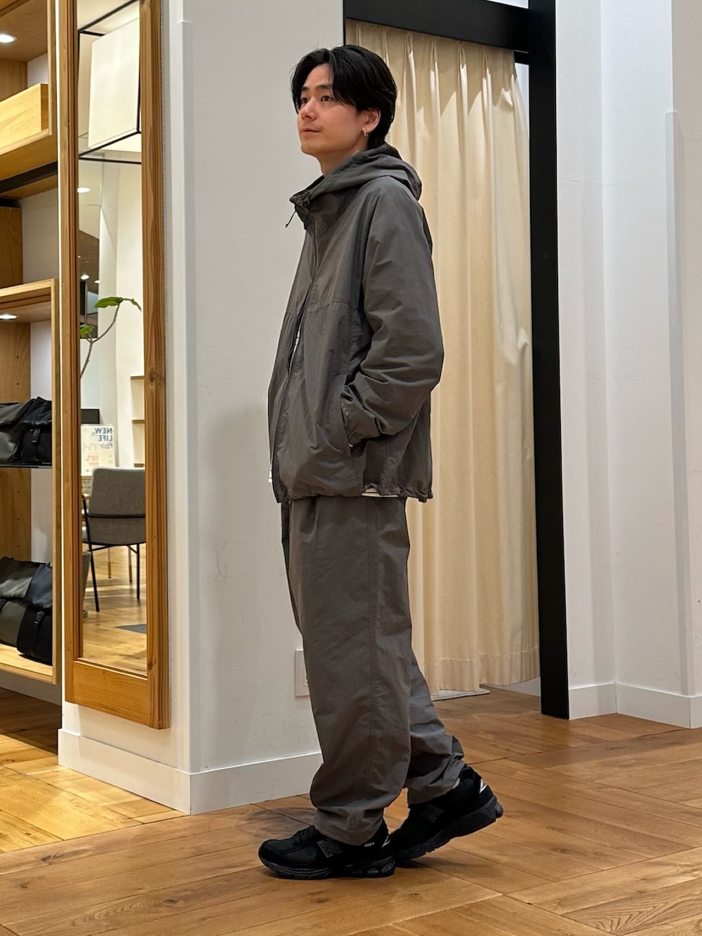 グレー系のナイロンジャケット、グレー系のその他パンツ、ホワイト系のTシャツ/カットソーを着用したメンズの春コーディネートの2枚目の写真