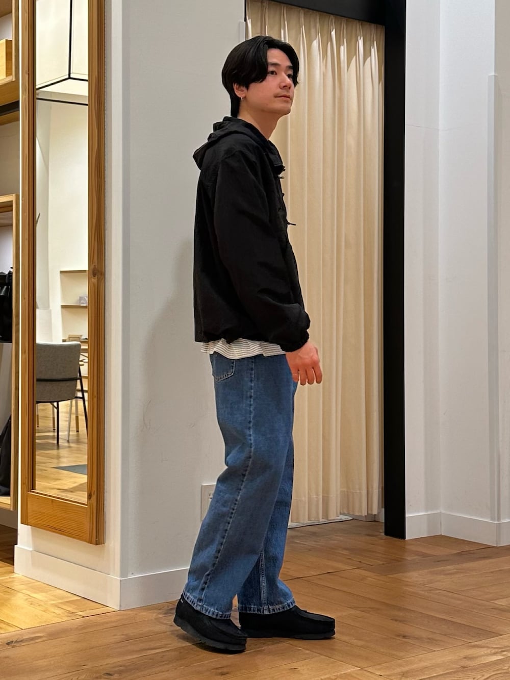 ブラック系のパーカー、ホワイト系のTシャツ/カットソー、ブルー系のデニムパンツを着用したメンズの冬コーディネートの4枚目の写真