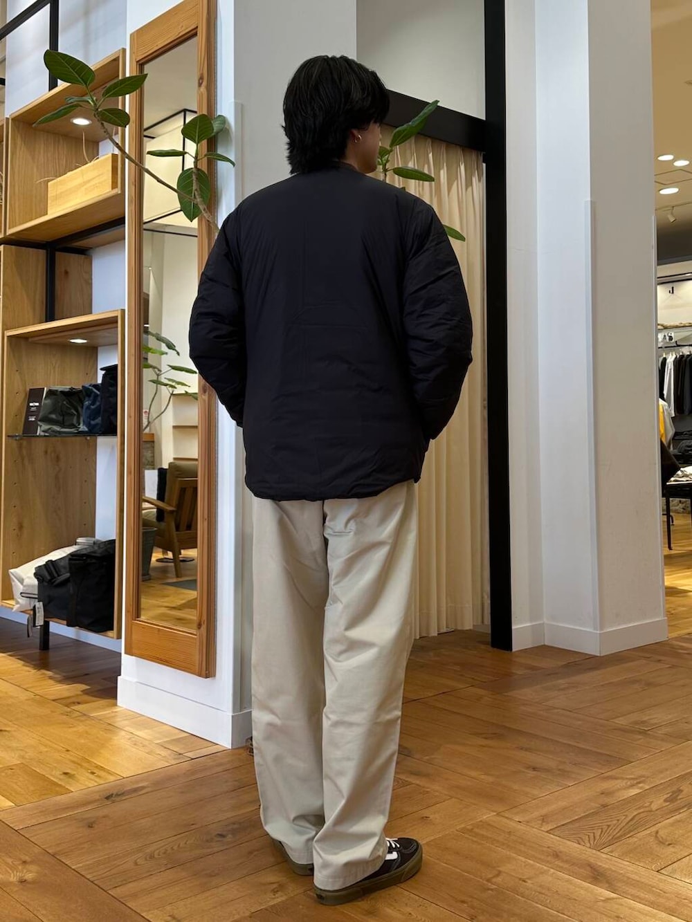 ホワイト系のチノパンツ、ブラック系のダウンジャケット/コート、ブラウン系のニット/セーターを着用したメンズの冬コーディネートの3枚目の写真