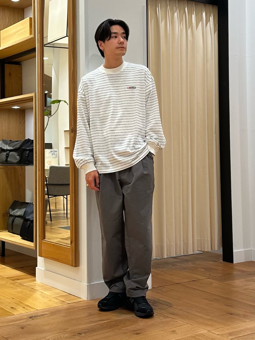 グレー系のナイロンジャケット、グレー系のその他パンツ、ホワイト系のTシャツ/カットソーを着用したメンズの春コーディネートの5枚目の写真