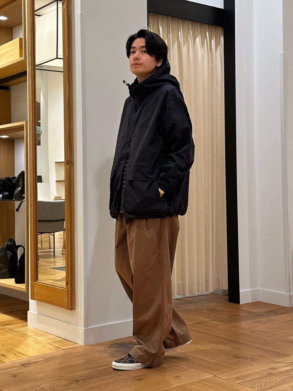 ブラック系のマウンテンパーカー、グレー系のTシャツ/カットソー、ブラウン系のその他パンツを着用したメンズの冬コーディネートの2枚目の写真