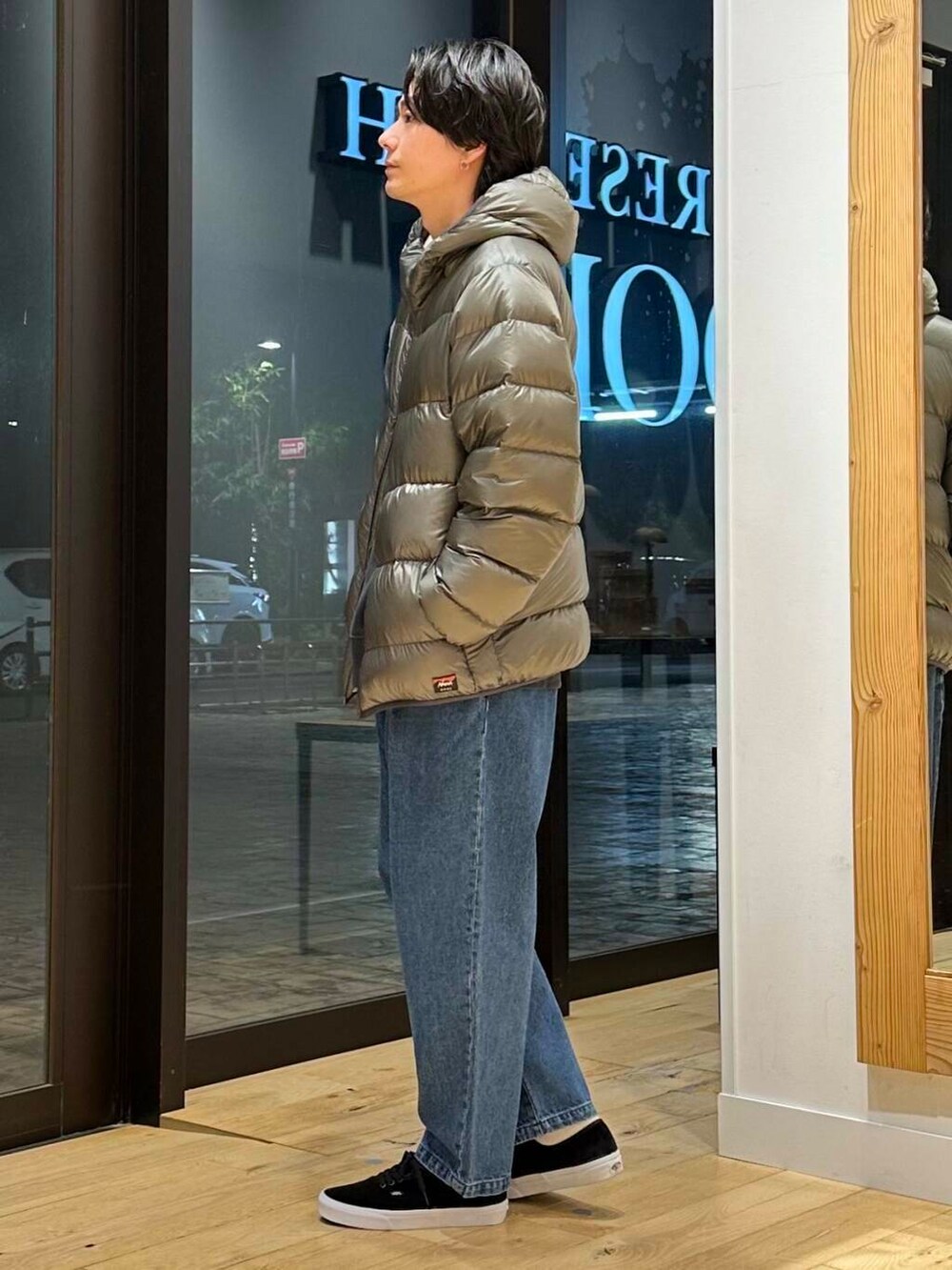 ブルー系のデニムパンツ、グリーン系のダウンジャケット/コート、グレー系のスウェットを着用したメンズの冬コーディネートの2枚目の写真