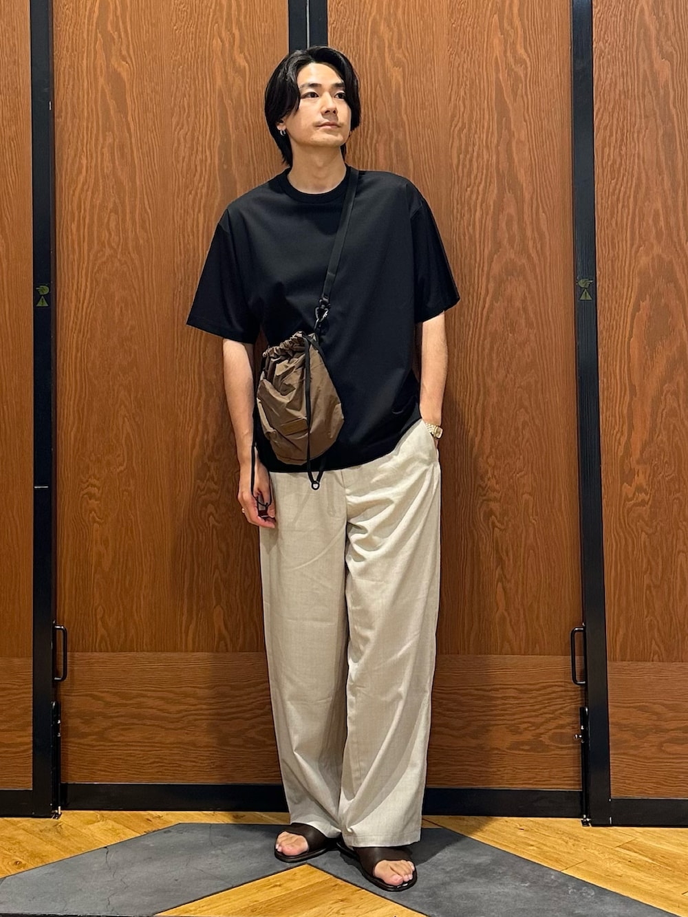 ブラック系のTシャツ/カットソー、ベージュ系のその他パンツ、ブラウン系のショルダーバッグを着用したメンズの夏コーディネートの3枚目の写真