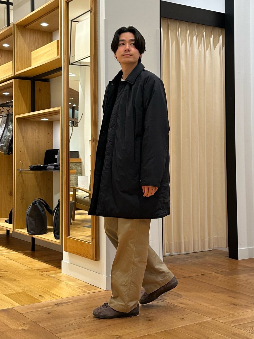 ブラック系のその他アウター、ブラック系のニット/セーター、ブラウン系のスニーカーを着用したメンズの冬コーディネートの3枚目の写真