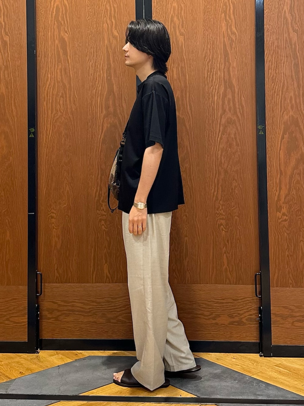 ブラック系のTシャツ/カットソー、ベージュ系のその他パンツ、ブラウン系のショルダーバッグを着用したメンズの夏コーディネートの2枚目の写真