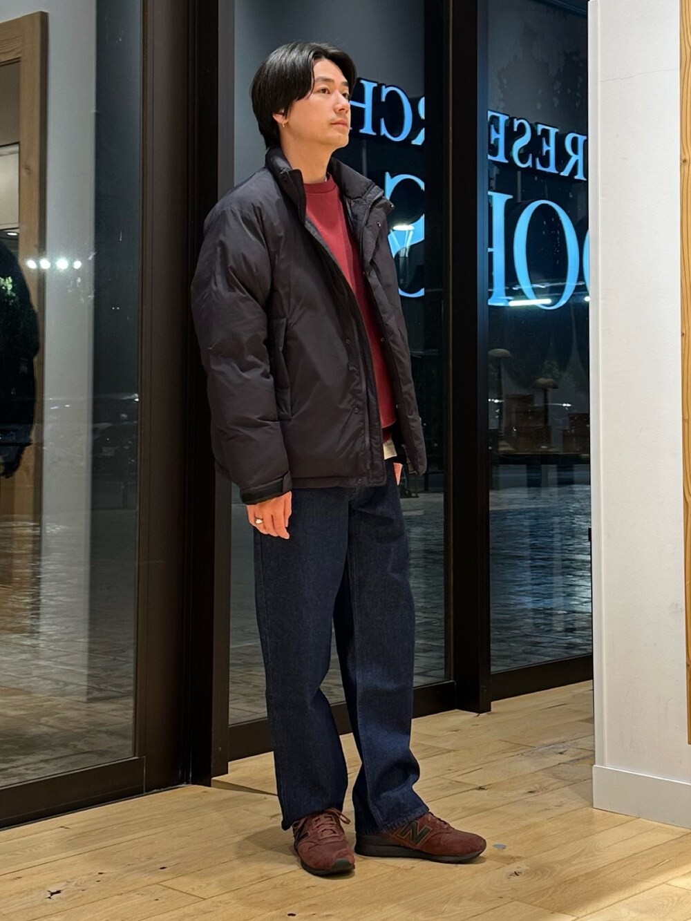 ブラック系のブルゾン、レッド系のスウェット、ブルー系のデニムパンツを着用したメンズの冬コーディネートの2枚目の写真