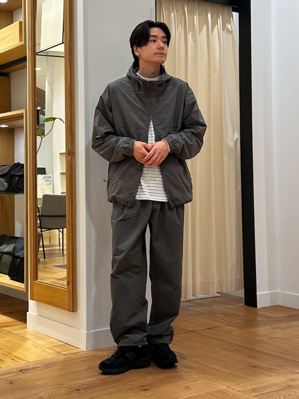 グレー系のナイロンジャケット、グレー系のその他パンツ、ホワイト系のTシャツ/カットソーを着用したメンズの春コーディネートの3枚目の写真