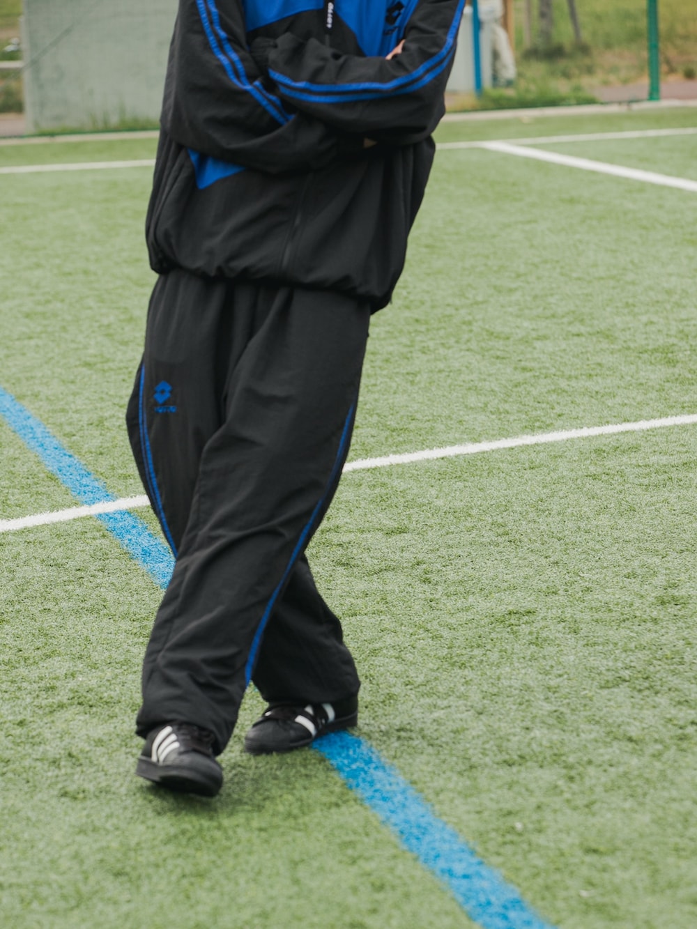 ブラック系のナイロンジャケット、ブラック系のその他パンツ、ブラック系のスニーカーを着用したメンズの秋コーディネートの4枚目の写真