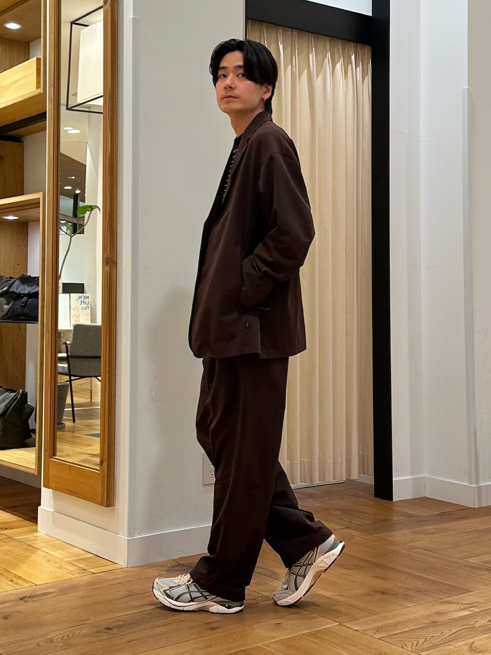 ブラウン系のその他アウター、ブラウン系のその他パンツ、ブラック系のTシャツ/カットソーを着用したメンズの春コーディネートの4枚目の写真