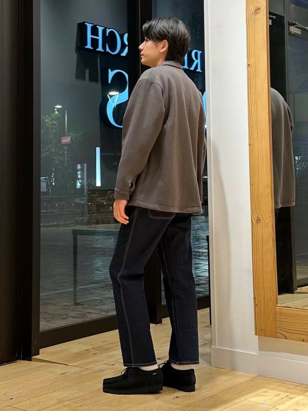 ブルー系のデニムパンツ、ブラック系のブーツ、ホワイト系のニット/セーターを着用したメンズの冬コーディネートの2枚目の写真