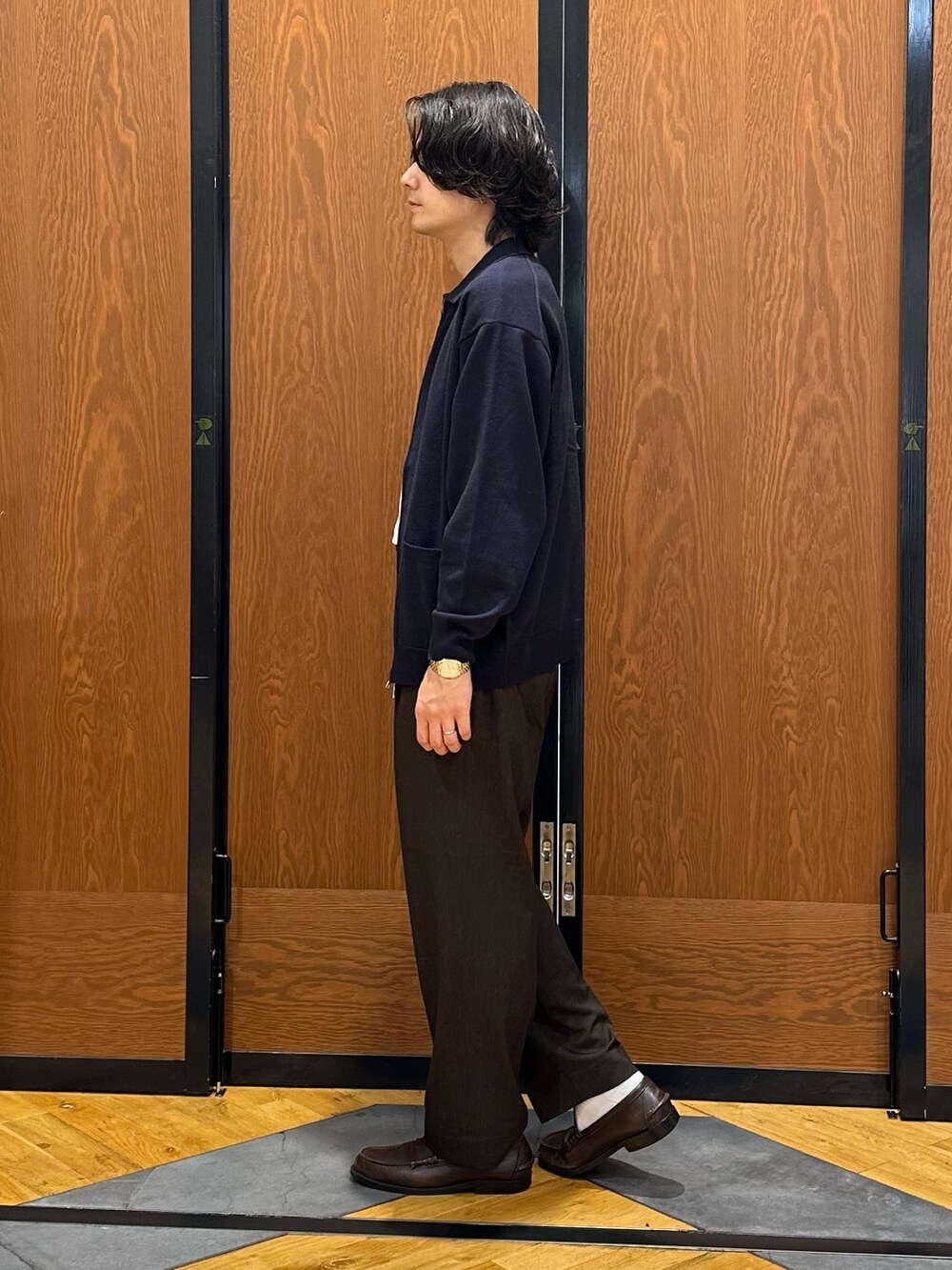 ブルー系のニット/セーター、ホワイト系のTシャツ/カットソー、ブラウン系のその他パンツを着用したメンズの秋コーディネートの4枚目の写真
