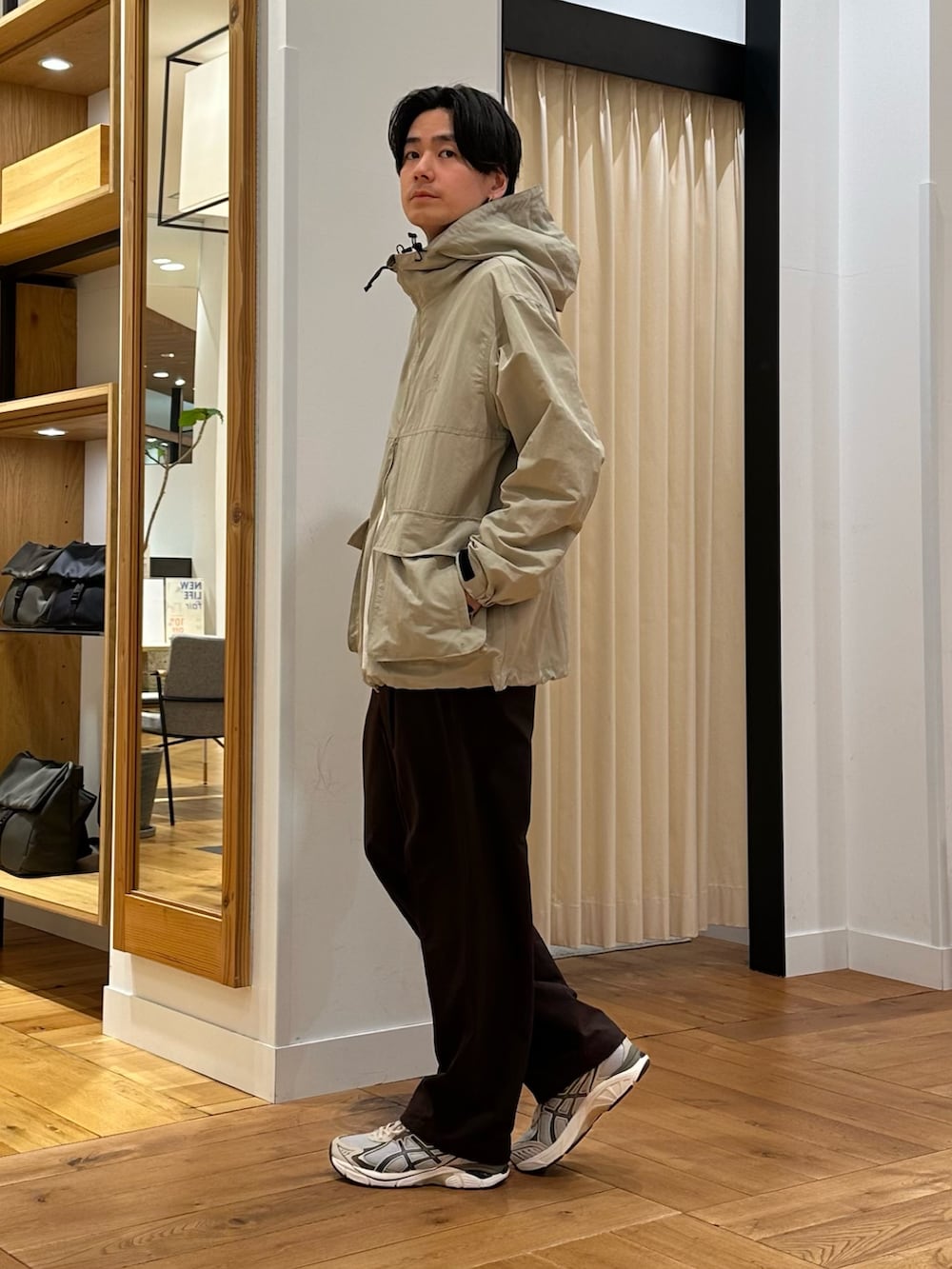 ベージュ系のマウンテンパーカー、ブラウン系のその他パンツ、グレー系のスニーカーを着用したメンズの春コーディネートの4枚目の写真