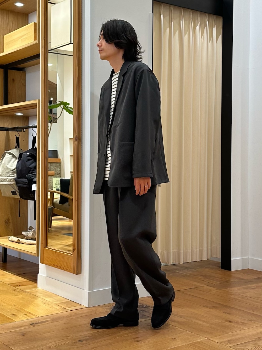 グレー系のその他アウター、レッド系のTシャツ/カットソー、グレー系のその他パンツを着用したメンズの秋コーディネートの2枚目の写真