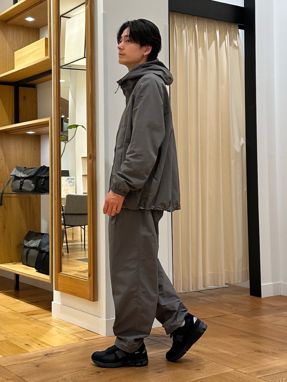 グレー系のナイロンジャケット、グレー系のその他パンツ、ホワイト系のTシャツ/カットソーを着用したメンズの春コーディネートの4枚目の写真