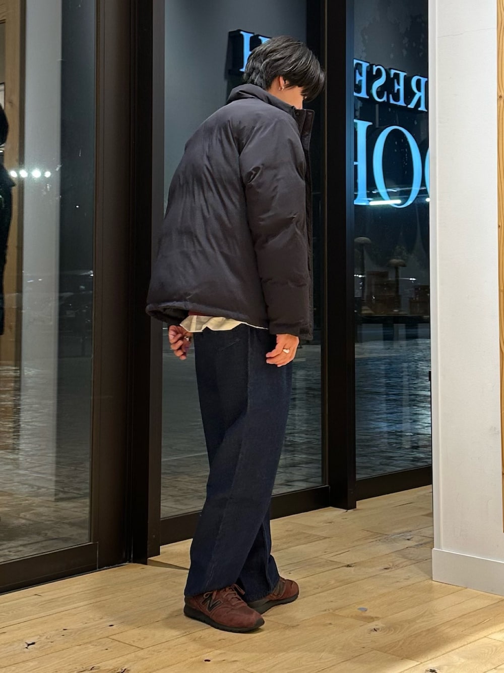 ブラック系のブルゾン、レッド系のスウェット、ブルー系のデニムパンツを着用したメンズの冬コーディネートの3枚目の写真