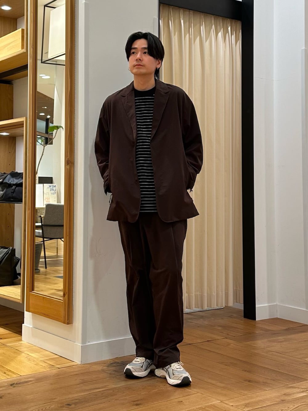 ブラウン系のその他アウター、ブラウン系のその他パンツ、ブラック系のTシャツ/カットソーを着用したメンズの春コーディネートの3枚目の写真