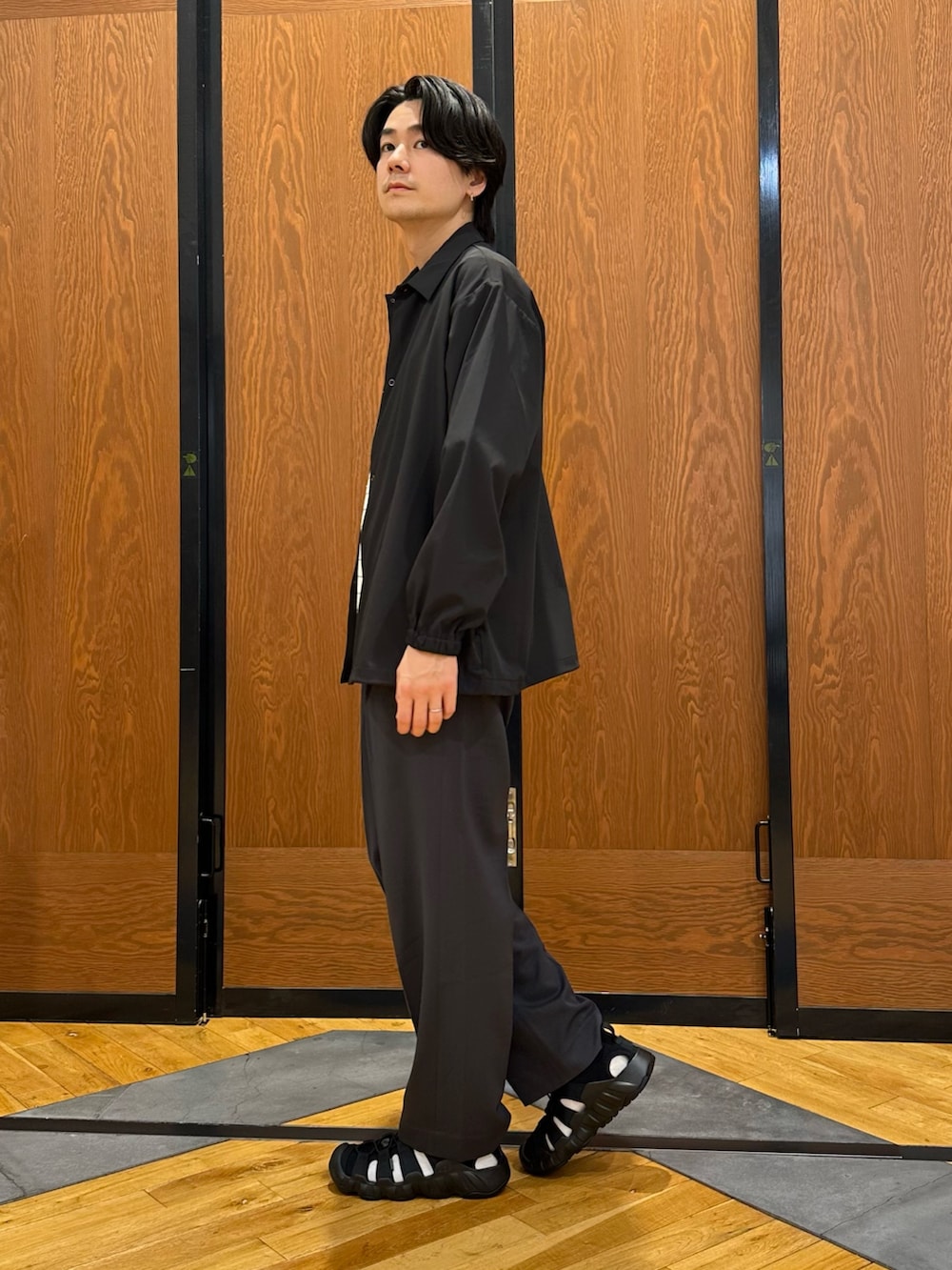 ブラック系のカーディガン/ボレロ、グレー系のその他パンツ、ブラック系のサンダルを着用したメンズの春コーディネートの2枚目の写真