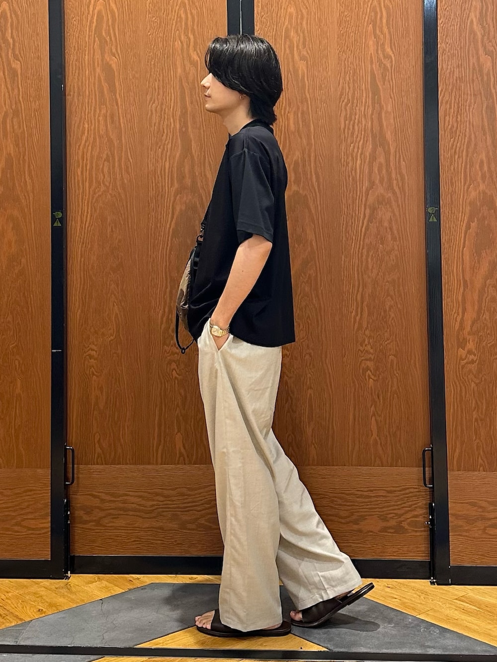 ブラック系のTシャツ/カットソー、ベージュ系のその他パンツ、ブラウン系のショルダーバッグを着用したメンズの夏コーディネートの4枚目の写真
