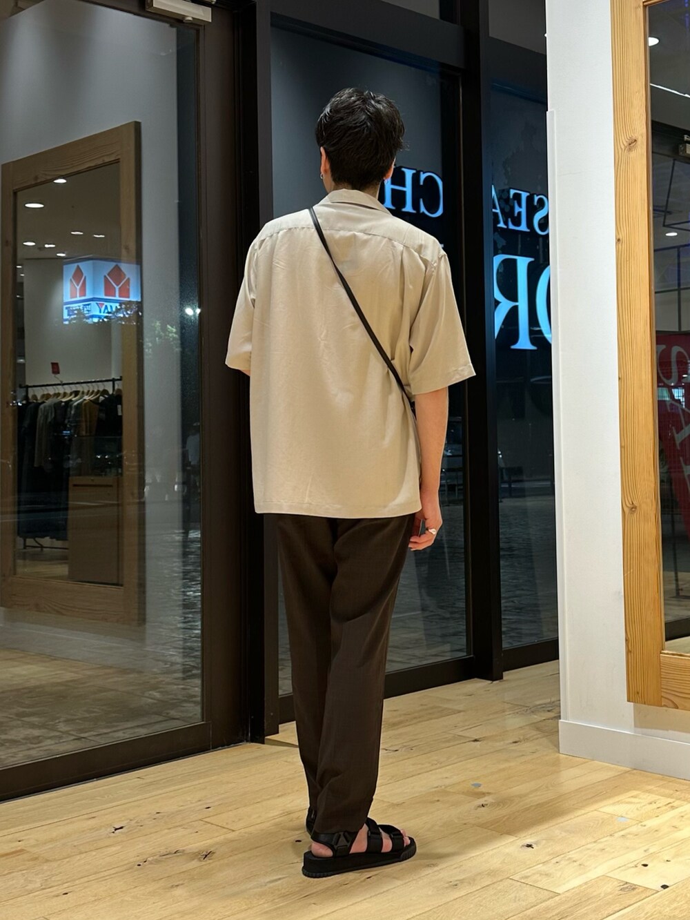 ブラック系のショルダーバッグ、ブラウン系のその他パンツ、ホワイト系のTシャツ/カットソーを着用したメンズの夏コーディネートの3枚目の写真