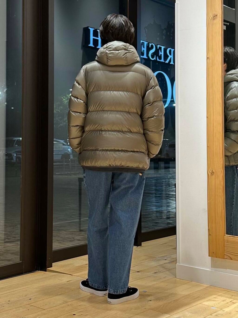 ブルー系のデニムパンツ、グリーン系のダウンジャケット/コート、グレー系のスウェットを着用したメンズの冬コーディネートの3枚目の写真