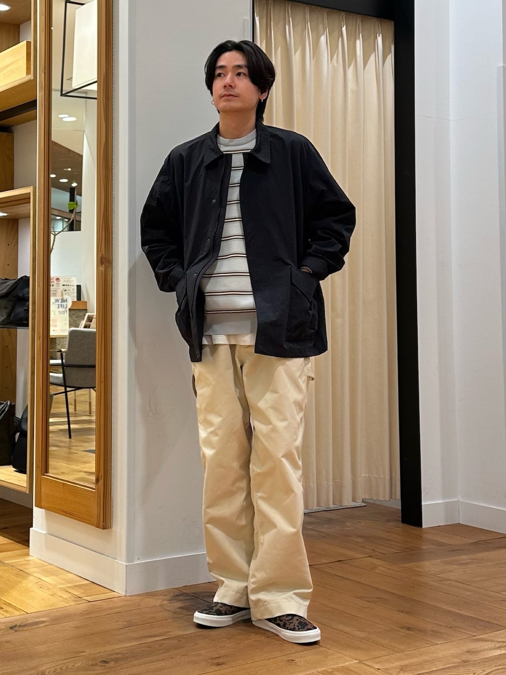 ブラック系のナイロンジャケット、グレー系のニット/セーター、ホワイト系のその他パンツを着用したメンズの春コーディネートの3枚目の写真