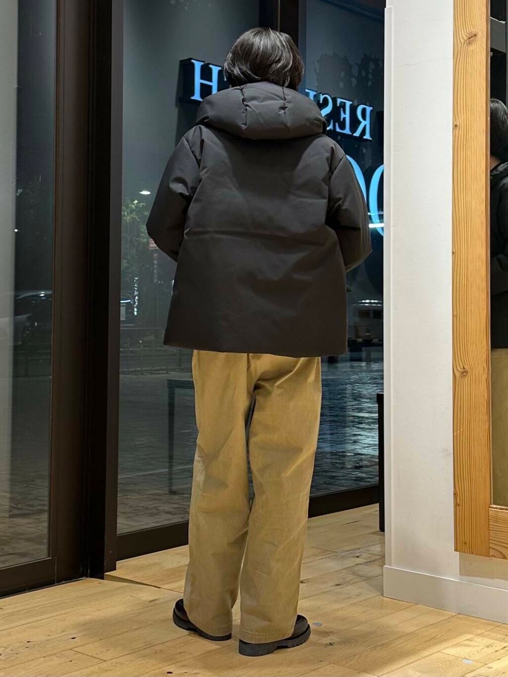 ブラック系のダウンジャケット/コート、ブラウン系のニット/セーター、ブラック系のドレスシューズを着用したメンズの冬コーディネートの3枚目の写真