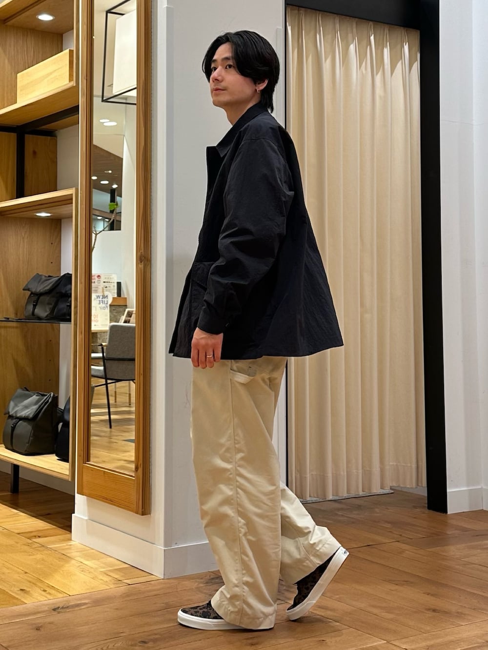 ブラック系のナイロンジャケット、グレー系のニット/セーター、ホワイト系のその他パンツを着用したメンズの春コーディネートの2枚目の写真