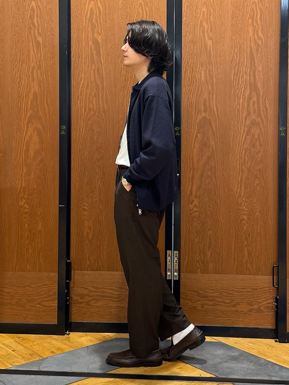 ブルー系のニット/セーター、ホワイト系のTシャツ/カットソー、ブラウン系のその他パンツを着用したメンズの秋コーディネートの2枚目の写真