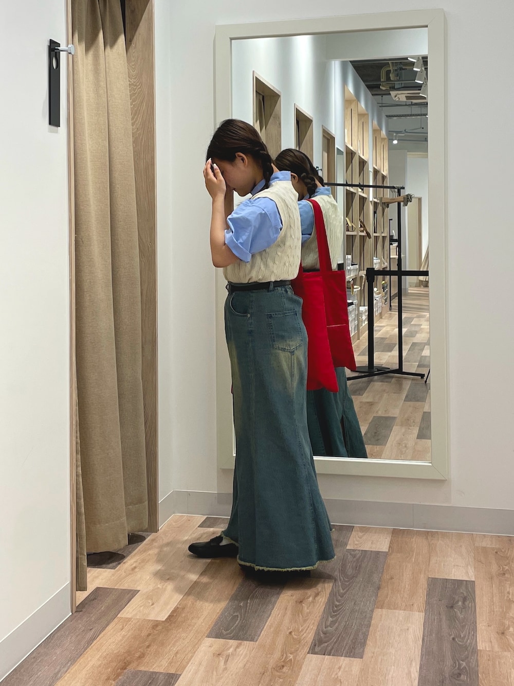 ブルー系のシャツ/ブラウス、ブルー系のスカート、レッド系のトートバッグを着用したレディースの夏コーディネートの2枚目の写真