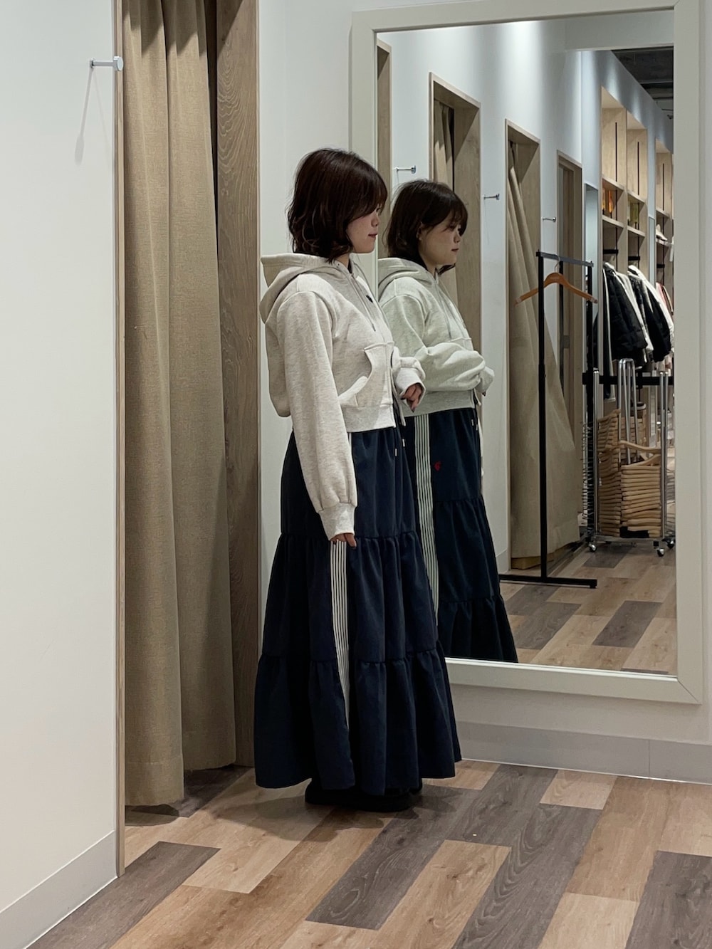 グレー系のパーカー、ブルー系のスカートを着用したレディースの冬コーディネートの2枚目の写真