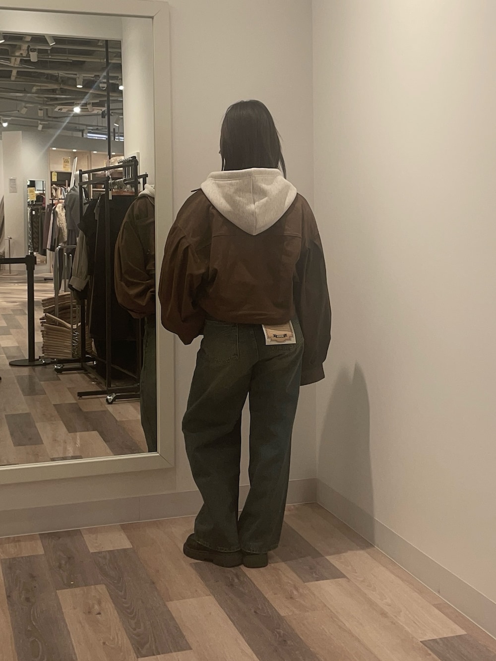 グレー系のパーカー、ブルー系のデニムパンツを着用したレディースの冬コーディネートの3枚目の写真