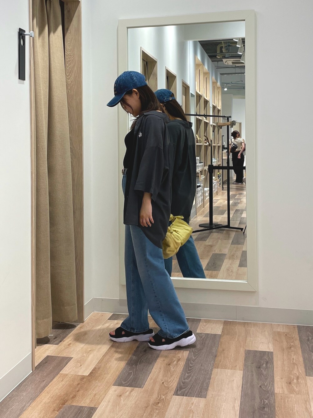 グレー系のシャツ/ブラウス、ブラック系のデニムパンツ、ブラック系のサンダルを着用したレディースの夏コーディネートの2枚目の写真