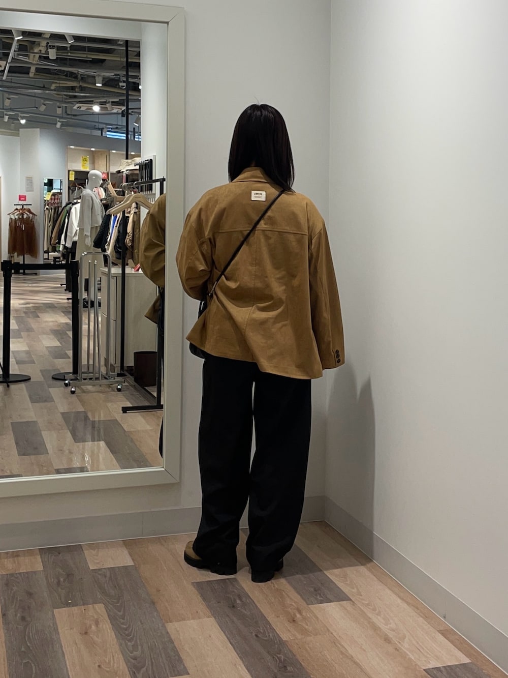 グレー系のスラックス、イエロー系のブルゾン、ホワイト系のニット/セーターを着用したレディースの冬コーディネートの3枚目の写真