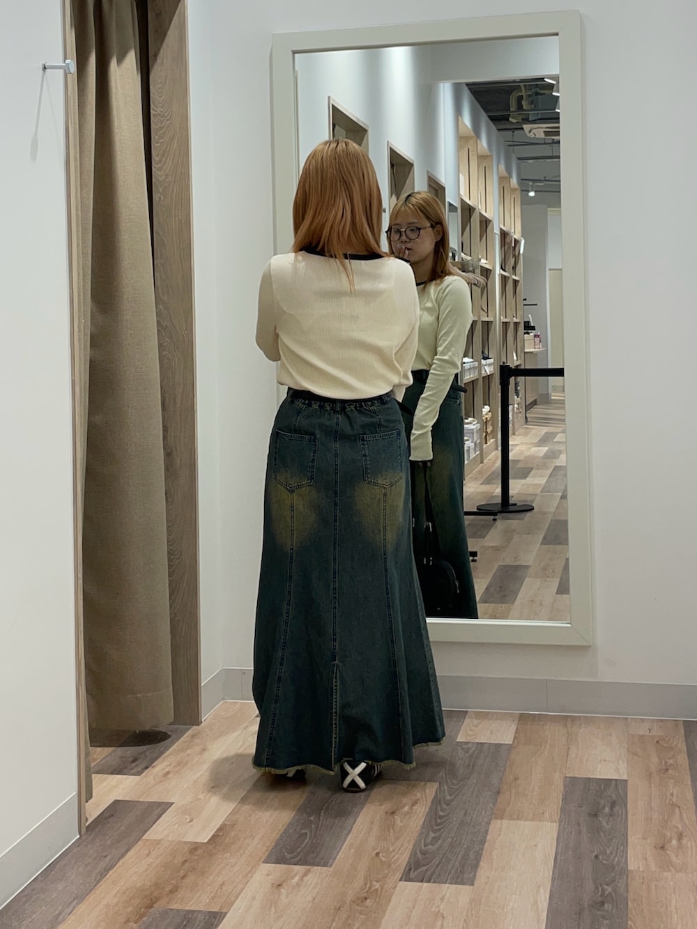 ブラウン系のボストンバッグ、ブルー系のスカート、ホワイト系のTシャツ/カットソーを着用したレディースの夏コーディネートの3枚目の写真