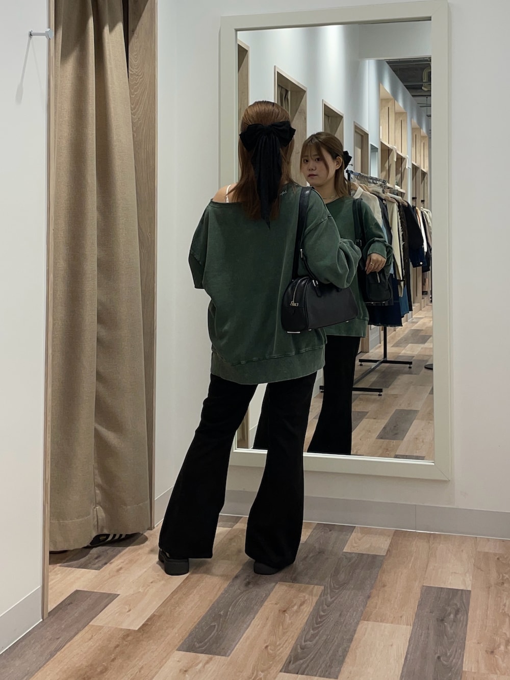 グリーン系のスウェット、ブラック系のその他パンツ、ブラウン系のボストンバッグを着用したレディースの秋コーディネートの3枚目の写真