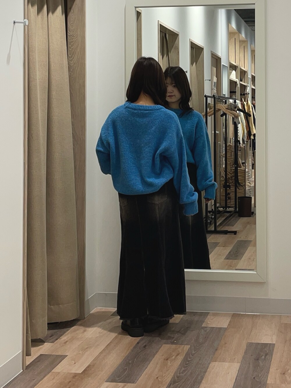 ブルー系のニット/セーター、ブラック系のスカートを着用したレディースの秋コーディネートの3枚目の写真