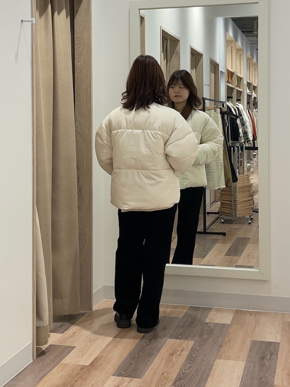 ホワイト系のブルゾン、グリーン系のニット/セーターを着用したレディースの冬コーディネートの4枚目の写真