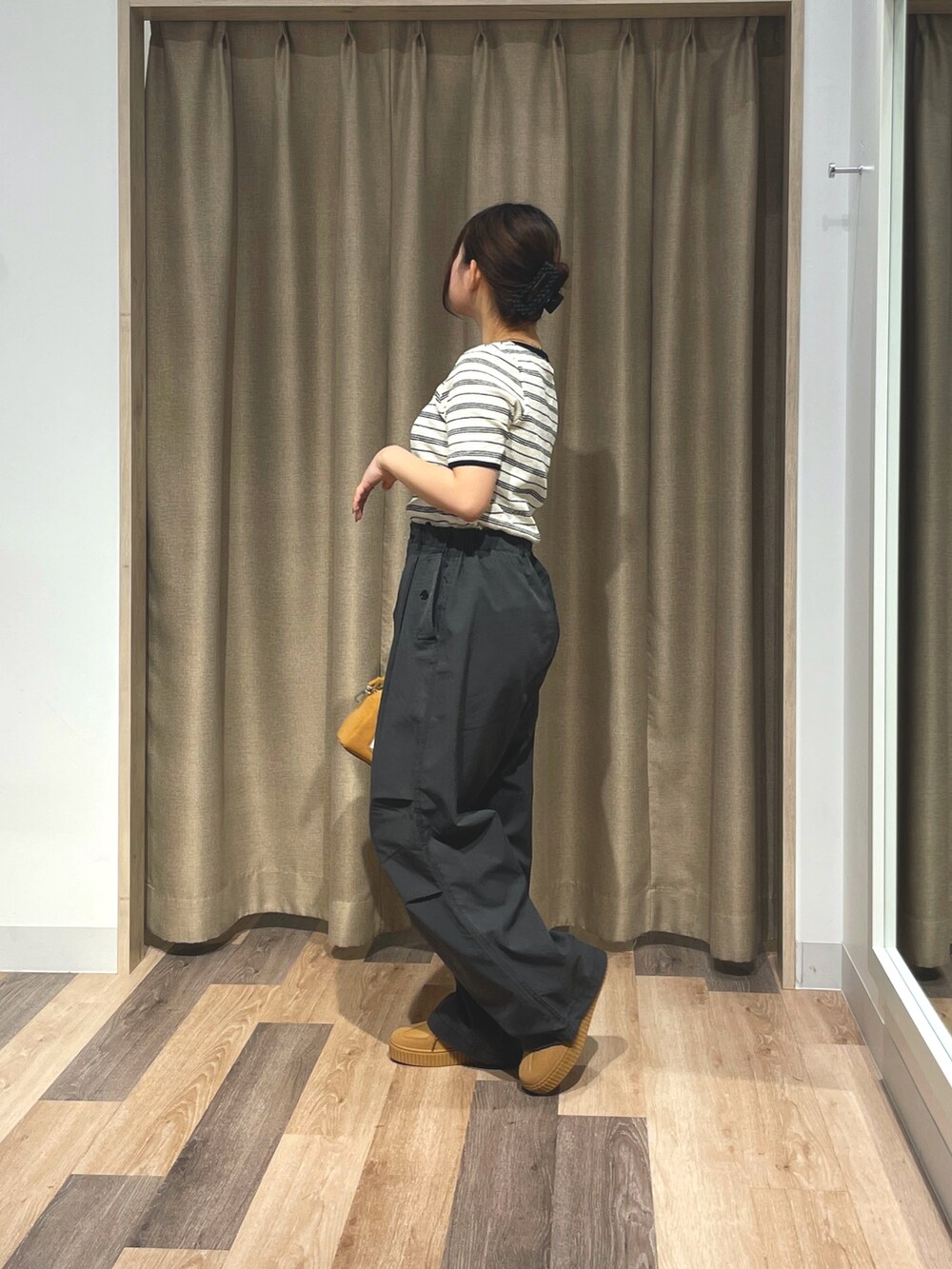 ホワイト系のTシャツ/カットソー、ブラック系のその他パンツ、イエロー系のボストンバッグを着用したレディースの夏コーディネートの2枚目の写真